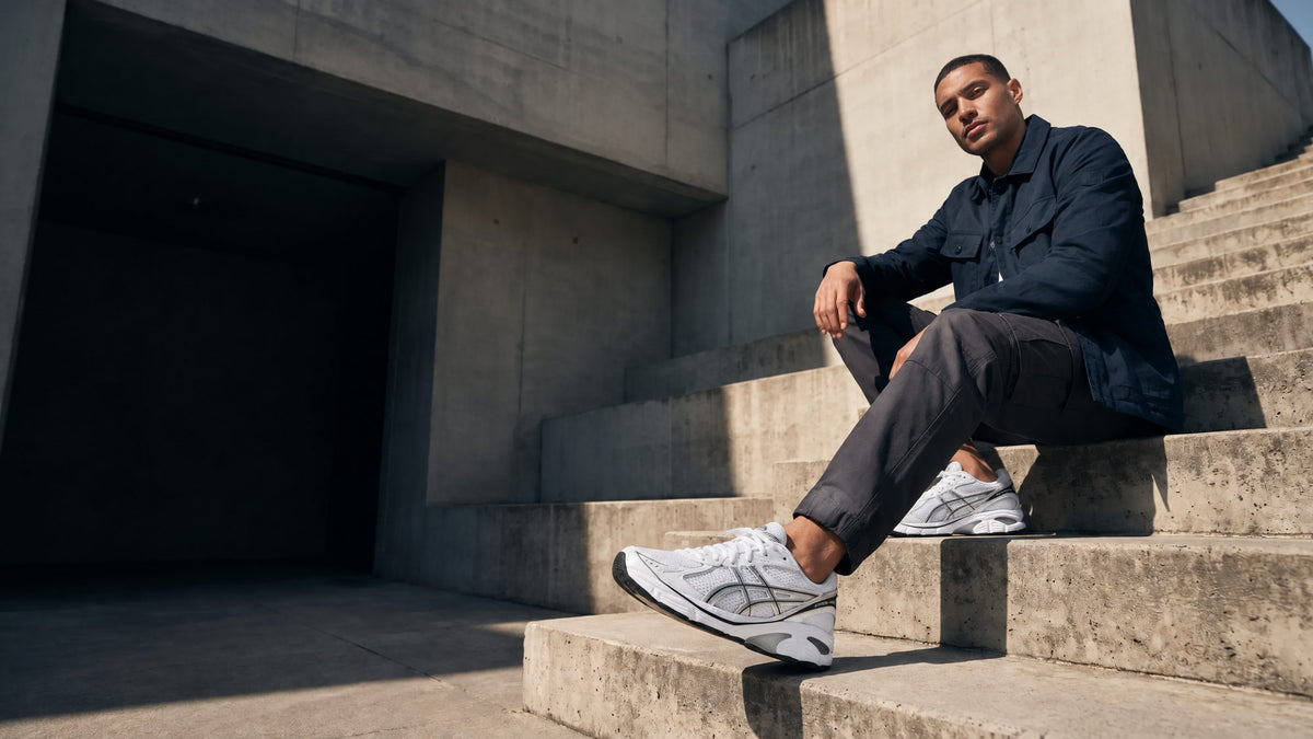 Model wearing trainers on concrete steps